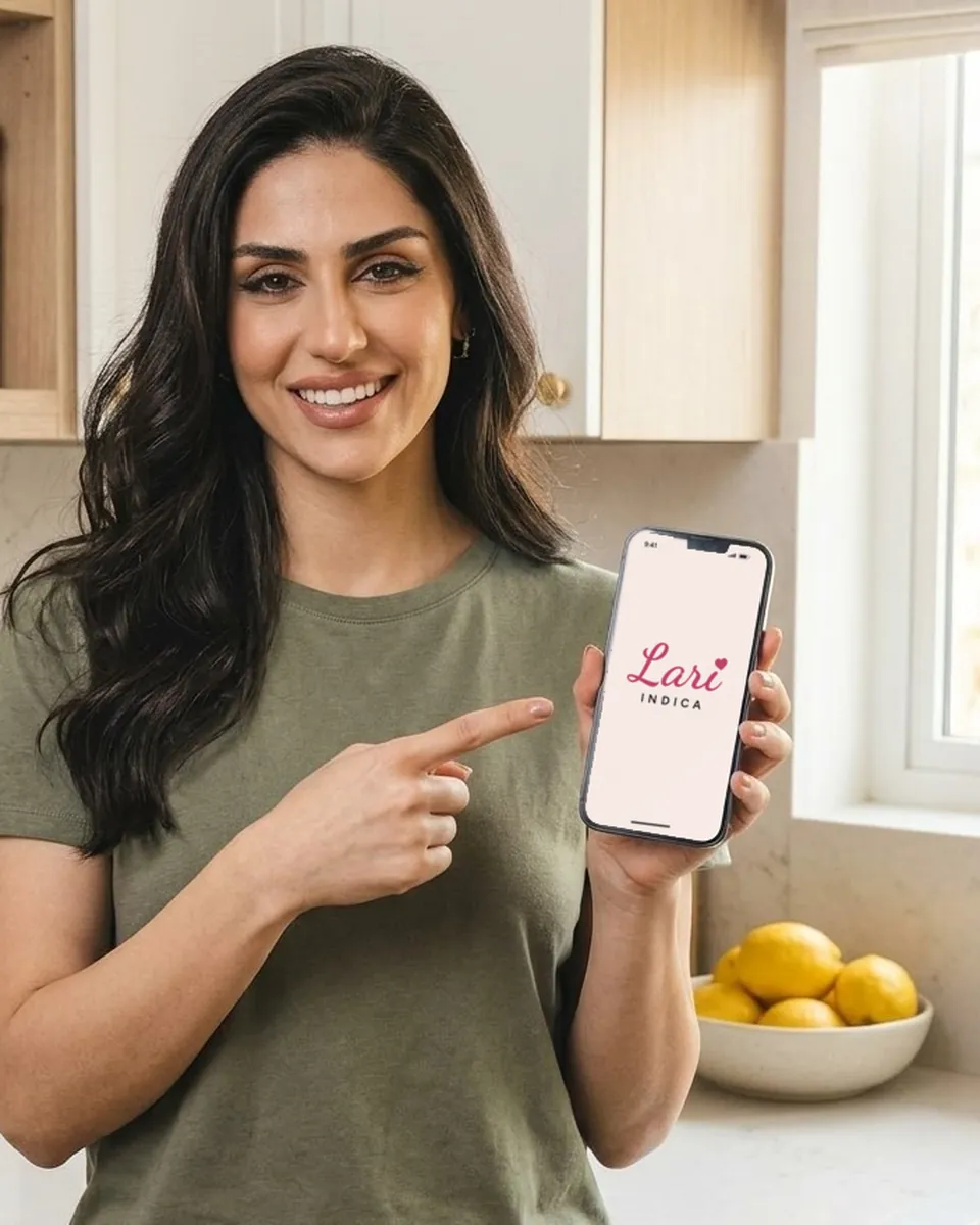 A Lari sorrindo e apontando para a logo do grupo na tela do celular